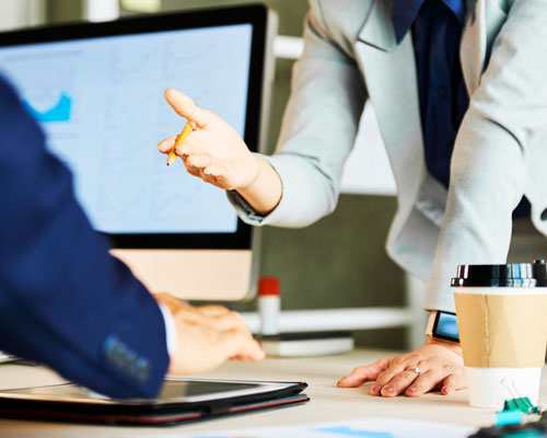 Two colleagues in an animated discussion across a desk